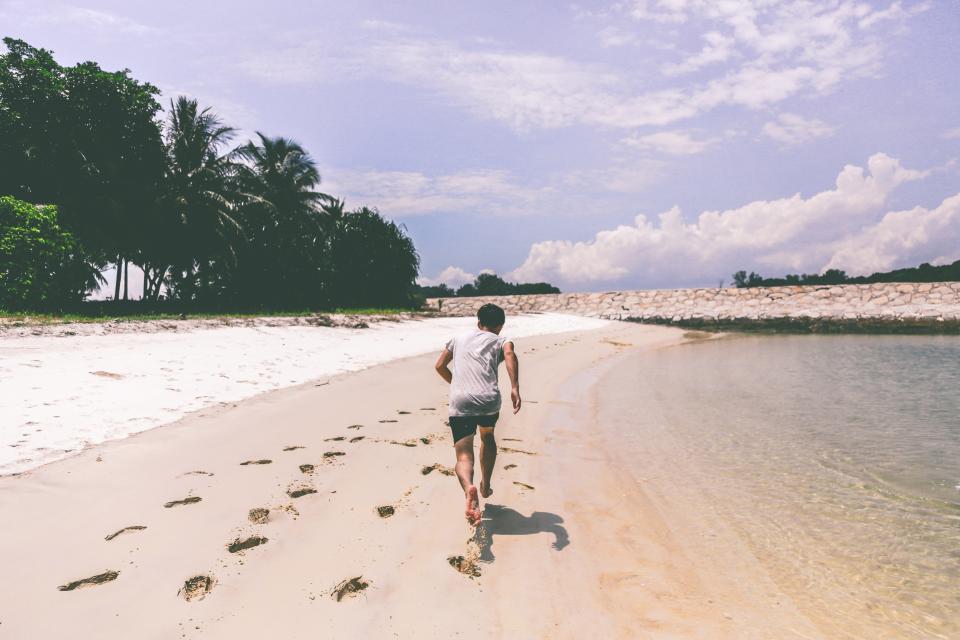 boy, guy, running, beach, sand, shore, footprints, fitness, exercise, shorts, tshirt, summer, sunny, palm trees, sky, people